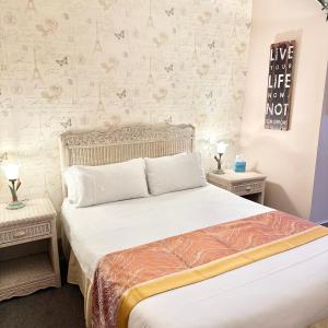 a bedroom with a bed with two night stands and two tables at Badgers Inn in Petworth