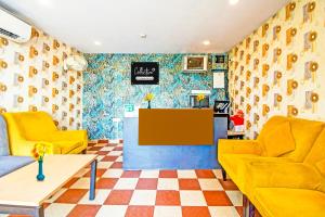 a lobby with two yellow chairs and a counter at Super Collection O Bisarjan Ghat Formerly Eden Rocks in Kolkata