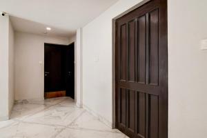 an empty hallway with a brown door and a room at Super Collection O Bisarjan Ghat Formerly Eden Rocks in Kolkata
