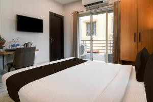 a bedroom with a bed and a desk and a window at Super Collection O Bisarjan Ghat Formerly Eden Rocks in Kolkata +38 photos