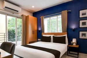 a bedroom with a bed and a blue wall at Super Collection O Bisarjan Ghat Formerly Eden Rocks in Kolkata