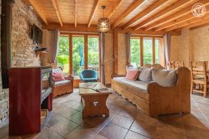 a living room with a couch and a tv at Gites le moulin in La Compôte