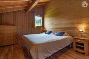a bedroom with a bed and a wooden wall at Gites le moulin in La Compôte +63 photos