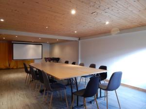 a conference room with a large wooden table and chairs at Gites le moulin in La Compôte