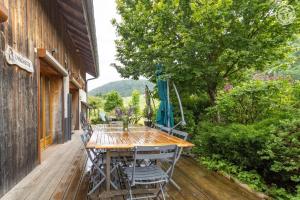 a wooden deck with a table and chairs at Gites le moulin in La Compôte