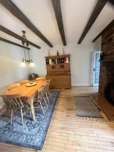 a dining room with a wooden table and chairs at Three Trees Cottage in Lochmaben