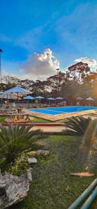a volley ball court with umbrellas and a pool at Pousada Sant`Ana in Sabará