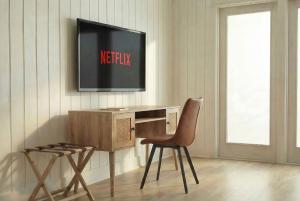 a room with a desk with a tv on the wall at Motel Seal Rock in Perce