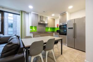 a kitchen with a table and chairs and a refrigerator at Single Ensuite Rooms In Central Preston in Preston
