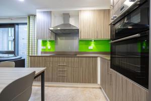 a kitchen with wooden cabinets and green accents at Single Ensuite Rooms In Central Preston in Preston