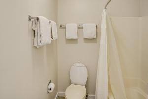 a white bathroom with a toilet and towels at Ski in-out, Slope and Pool Views 1BR at Country Inn in Hancock