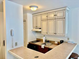 a kitchen with white cabinets and a sink at Ski in-out, Slope and Pool Views 1BR at Country Inn in Hancock