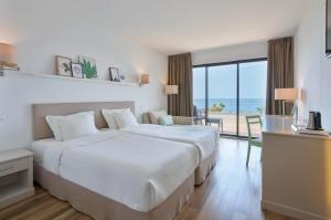 a bedroom with a large bed and a view of the ocean at Caloura Hotel Resort in Caloura +12 photos