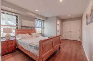 a bedroom with a large wooden bed and a window at The Anchorage Cape May in Cape May