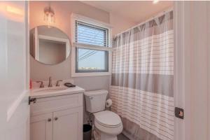 a bathroom with a toilet and a sink and a mirror at The Anchorage Cape May in Cape May