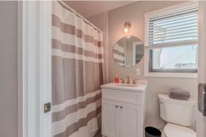 a bathroom with a sink and a toilet and a mirror at The Anchorage Cape May in Cape May
