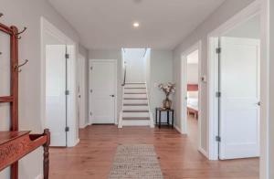 a hallway with white walls and a staircase in a house at The Anchorage Cape May in Cape May +10 photos