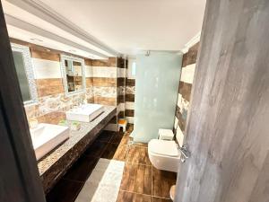 a bathroom with two sinks and a toilet at Tropical Apartment Hanioti in Hanioti +22 photos