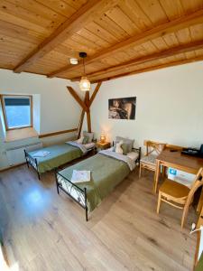 a large room with two beds and a table at Młyn Wielisław Agroturystyka i Restauracja in Sędziszowa