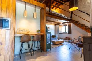 a room with a bar with stools and a table at Casa do Cabeço in Maiorga