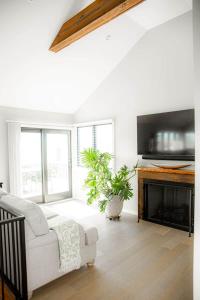 a living room with a white couch and a fireplace at The Fisherman's Cottage in Cape May