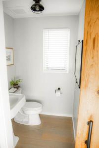 a bathroom with a toilet and a sink and a window at The Fisherman's Cottage in Cape May