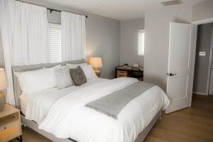 a bedroom with a large white bed with white pillows at The Fisherman's Cottage in Cape May