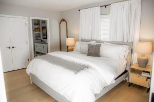 a bedroom with a large white bed and a window at The Fisherman's Cottage in Cape May +14 photos