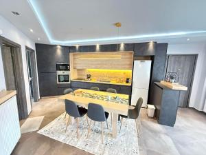 a kitchen with a table and chairs and a refrigerator at Tropical Apartment Hanioti in Hanioti
