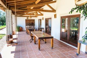 a patio with wooden tables and chairs on it at Casa do Cabeço in Maiorga