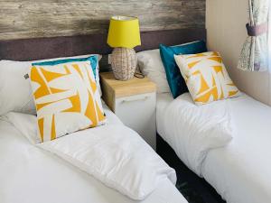 two beds with pillows and a lamp on a night stand at Bordeaux in Heysham +16 photos