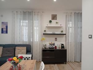 a living room with a blue couch and a table at Trieste Apartment in Reggio di Calabria