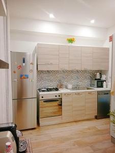 a kitchen with a stainless steel refrigerator and wooden cabinets at Trieste Apartment in Reggio di Calabria