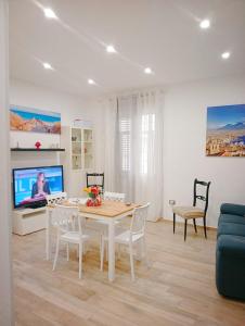 a living room with a table and a tv at Trieste Apartment in Reggio di Calabria
