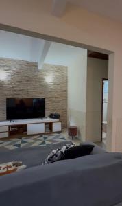 a bedroom with a flat screen tv and a bed at Casa com área de lazer em Xerém in Duque de Caxias