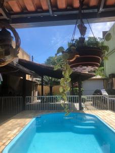 a potted plant is hanging over a swimming pool at Casa com área de lazer em Xerém in Duque de Caxias