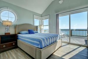 a bedroom with a bed with a view of the ocean at Tipsy Turtle North- Oceanfront Oasis - Pool - Dog Friendly in Surf City