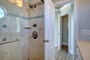 a bathroom with a shower with a glass door at Tipsy Turtle North- Oceanfront Oasis - Pool - Dog Friendly in Surf City