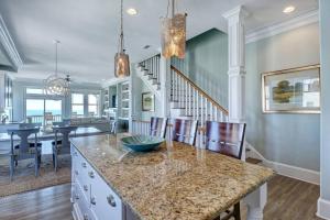 a kitchen and dining room with a island with chairs at Tipsy Turtle North- Oceanfront Oasis - Pool - Dog Friendly in Surf City