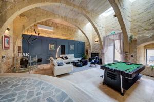 a living room with a pool table in a building at Zaffir Retreat in Żebbuġ