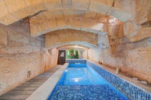 an indoor swimming pool in a stone walled building at Zaffir Retreat in Żebbuġ