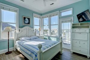 a bedroom with a bed with blue walls and windows at Tipsy Turtle South-bOceanfront Oasis - Dog Friendly - Pool in Surf City