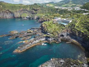 an aerial view of a resort on a rocky coast at Caloura Hotel Resort in Caloura