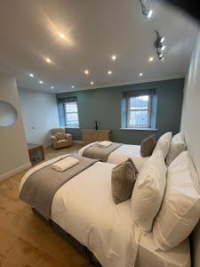 a large bedroom with two beds and a chair at Three Trees Cottage in Lochmaben