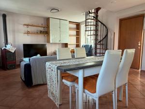 a living room with a table and white chairs at Casa dei Gufi in Cella