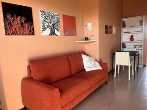 a living room with a red couch and a table at Urban Po Mansarda in Santa Maria Maddalena +9 photos