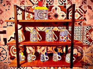 a shelf full of cups and plates on a wall at La Macchia sui Sassi in Matera