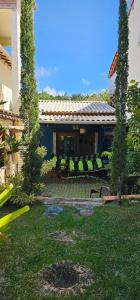a house with green chairs in a yard at a casinha in Serra Grande