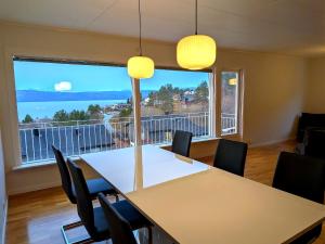 ein Esszimmer mit Tisch und Stühlen und einem großen Fenster in der Unterkunft Aurora Fjord View Escape Narvik garden sleeps 10 in Narvik