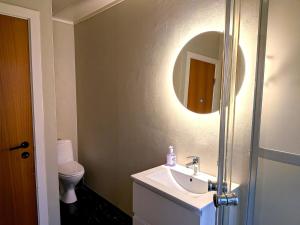 ein Badezimmer mit Waschbecken, Spiegel und Toilette in der Unterkunft Aurora Fjord View Escape Narvik garden sleeps 10 in Narvik + 17 Fotos